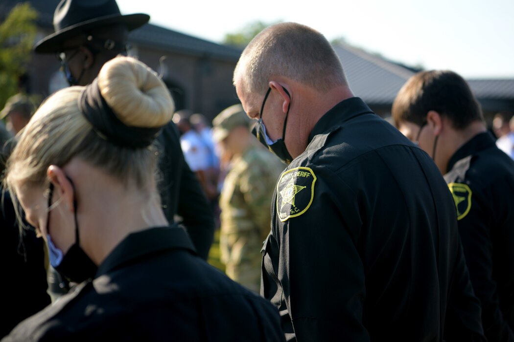 Photo of Sumter County Law Enforcement officers lowering their head in prayer during a 9/11 ceremony 