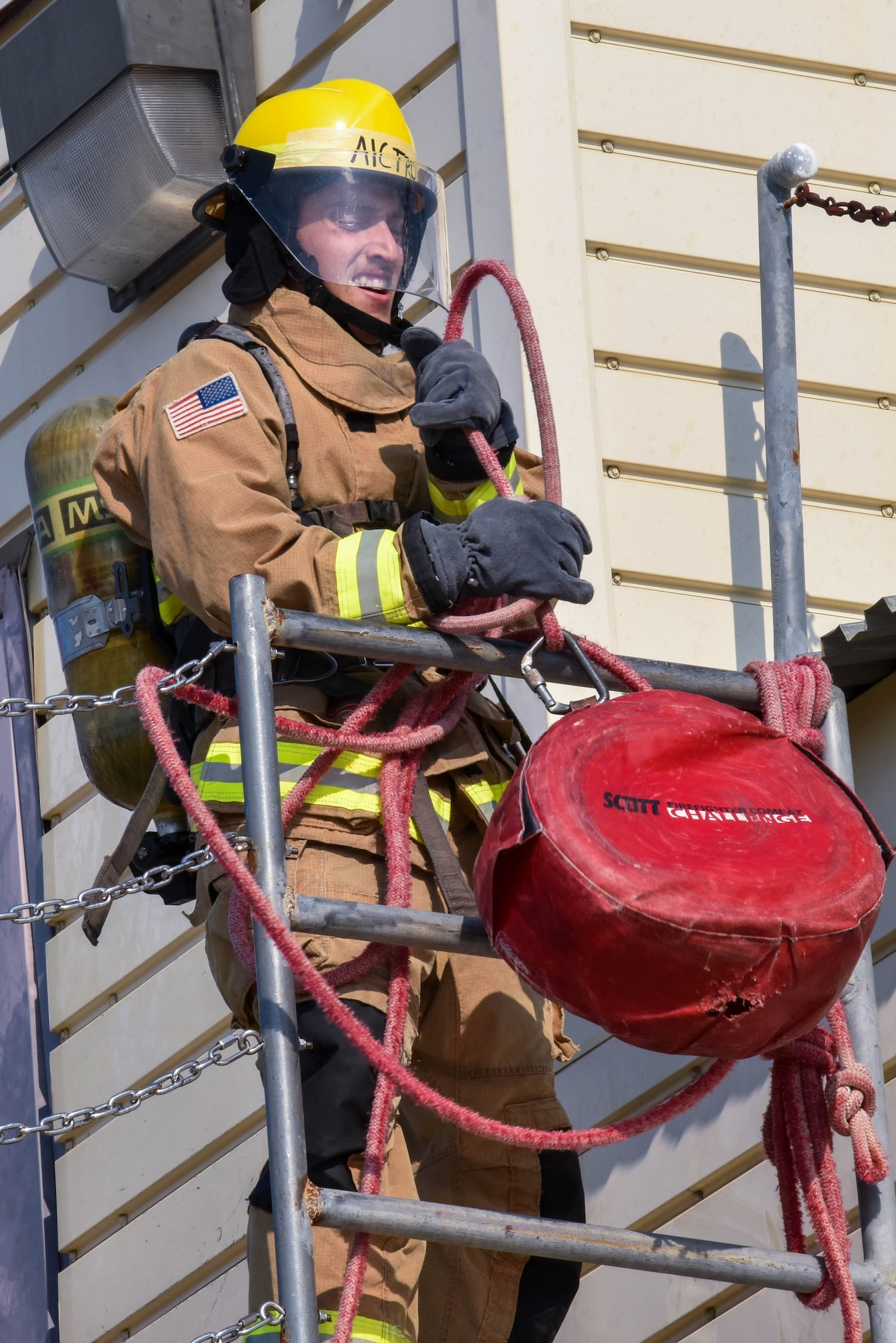 A 312th Training Squadron student hoists up a load using a rope during the Blood, Sweat, and Stairs event at the Louis F. Garland Department of Defense Fire Academy on Goodfellow Air Force Base, Texas, Sept. 11, 2021. During the challenge this activity was used to simulate hoisting tools up the side of a building, training participants for rescue scenarios. (U.S. Air Force photo by Senior Airman Jermaine Ayers)