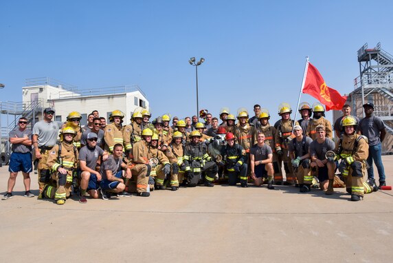 312th Training Squadron students and instructors pose for a group photo during the Blood, Sweat, and Stairs event at the Louis F. Garland Department of Defense Fire Academy on Goodfellow Air Force Base, Texas, Sept. 11, 2021. The event was its ninth annual and payed tribute the firefighters and first responders who lost their lives on 9/11. (U.S. Air Force photo by Senior Airman Jermaine Ayers)