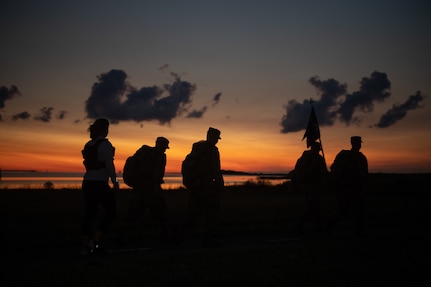 A group of Airmen walk and run outside in an event.