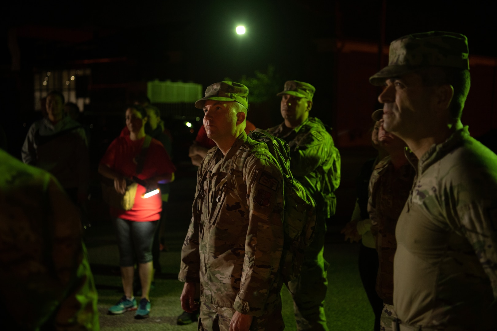 A group of Airmen walk and run outside in an event.