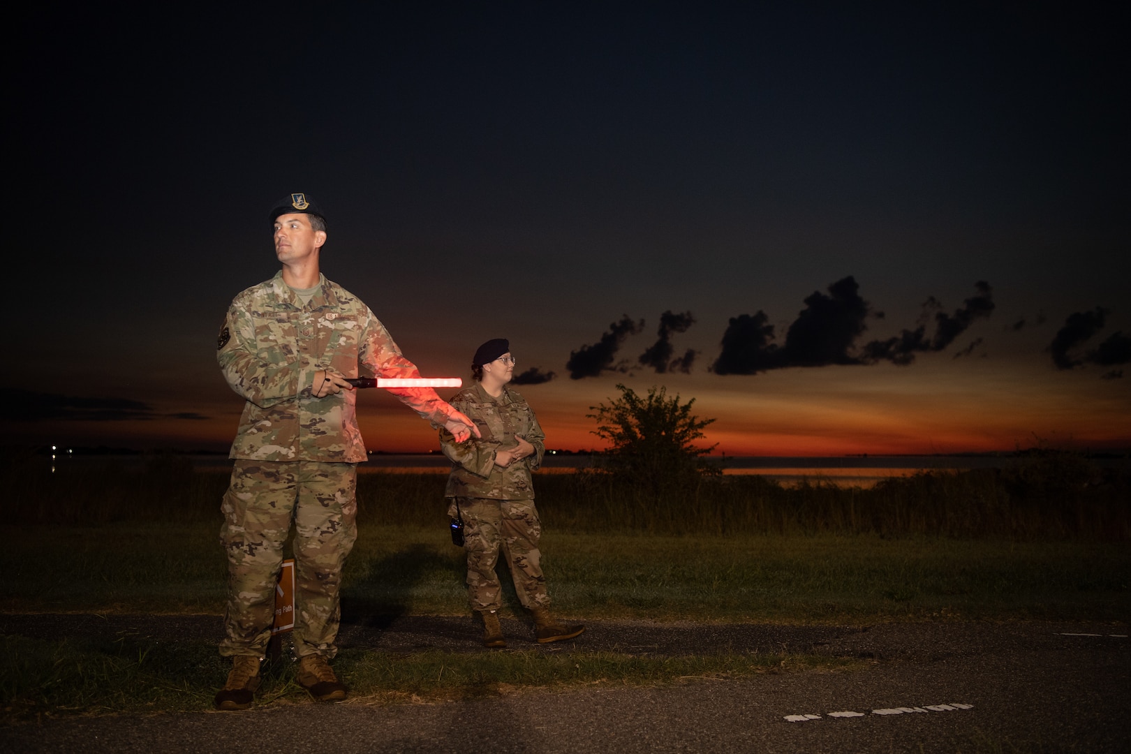 A group of Airmen walk and run outside in an event.