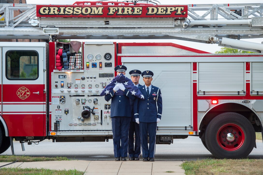 Tech. Sgt. Benjiman Durr, 434th Security Forces Squadron member, flanked by two other members of the Grissom Honor Guard, holds a folded American Flag while standing ready to march down the path toward the base flag pole during a 9/11 remembrance ceremony at Grissom Air Reserve Base, Indiana, Sept. 11, 2021. The ceremony marked the 20th anniversary of the attack that took the lives of almost 3000 Americans. (U.S. Air Force photo by Staff Sgt. Michael Hunsaker)