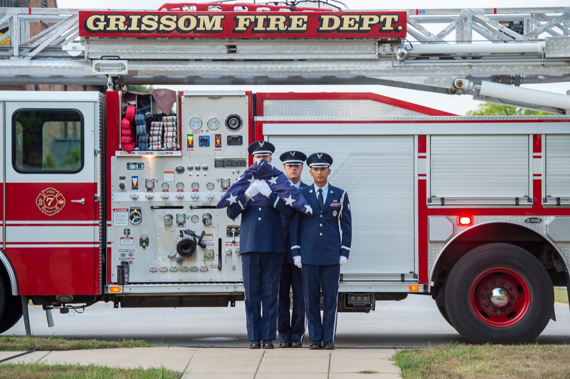 Tech. Sgt. Benjiman Durr, 434th Security Forces Squadron member, flanked by two other members of the Grissom Honor Guard, holds a folded American Flag while standing ready to march down the path toward the base flag pole during a 9/11 remembrance ceremony at Grissom Air Reserve Base, Indiana, Sept. 11, 2021. The ceremony marked the 20th anniversary of the attack that took the lives of almost 3000 Americans. (U.S. Air Force photo by Staff Sgt. Michael Hunsaker)