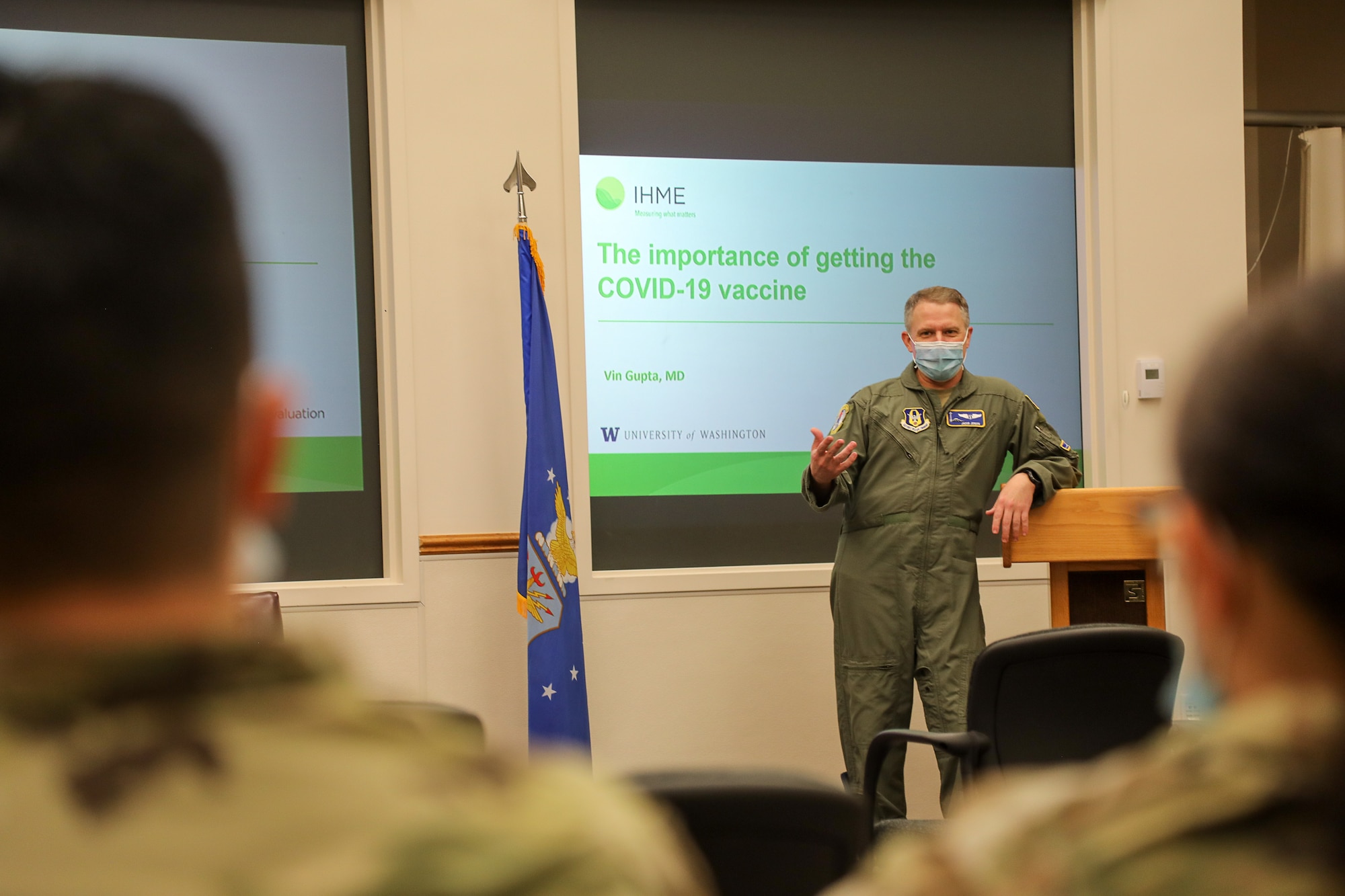 Airman briefs airmen on COVID-19 vaccine.