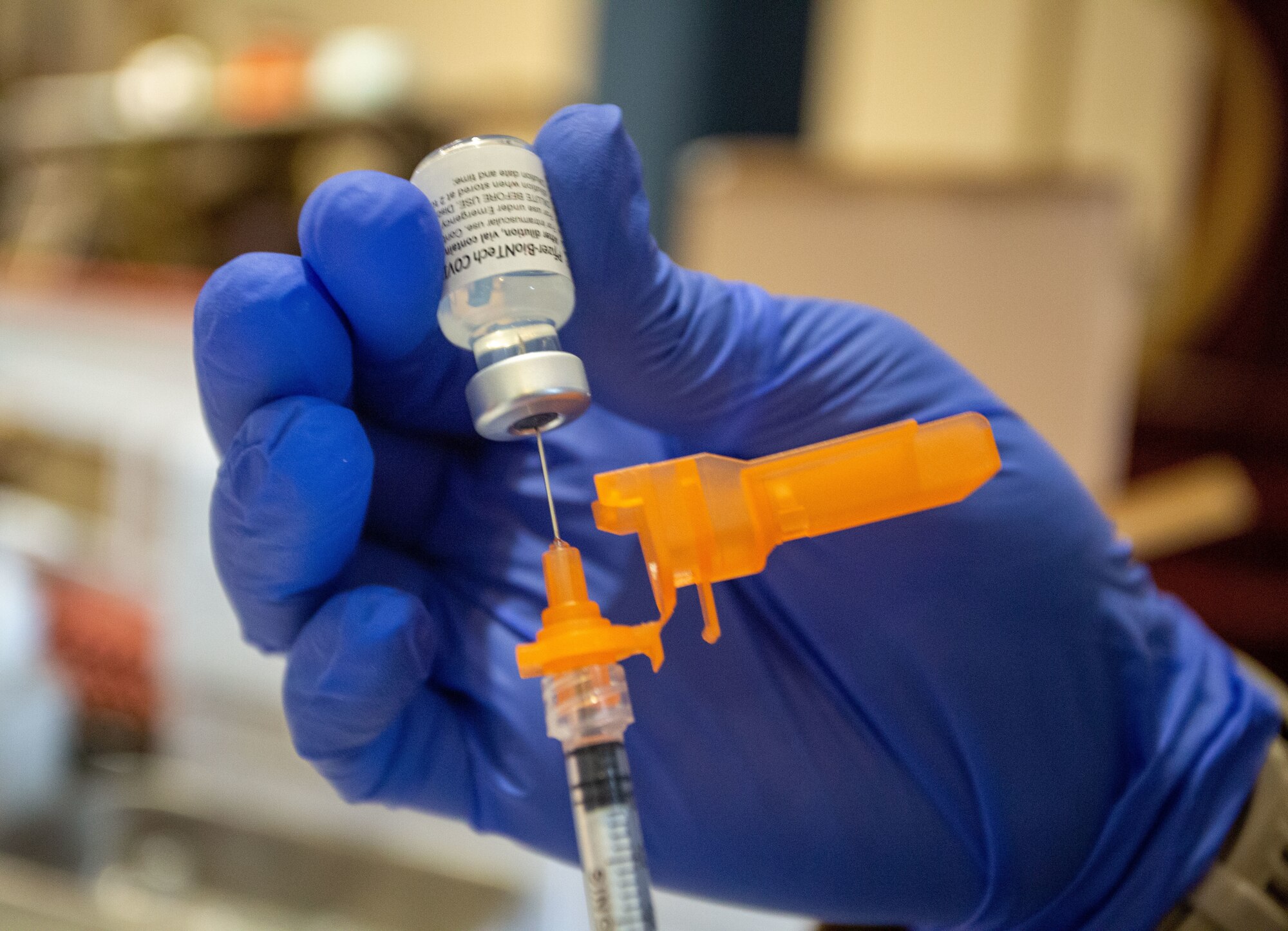 Someone holds the Pfizer-BioNTech COMIRNATY COVID-19 vaccine vial.