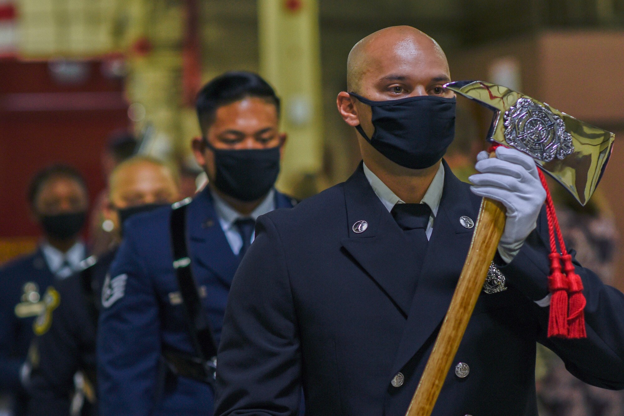 A firefighter carrying a ceremonial fire axe.
