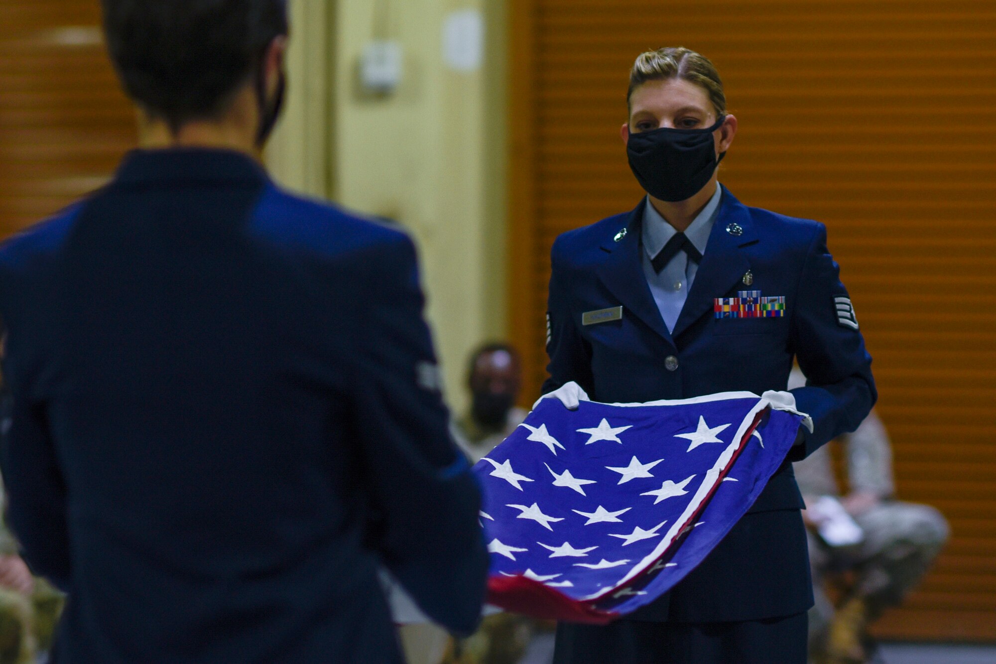 Two Airmen folding a flag.