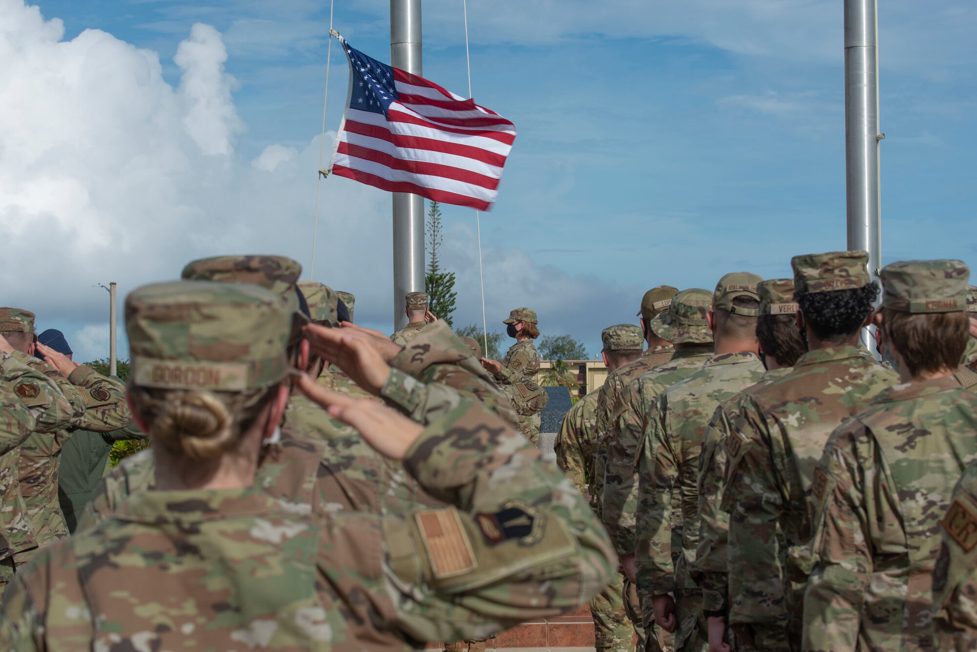 Airmen saluting the flag.