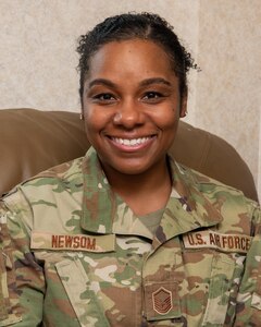 Master Sgt. Keona Newsom, 192nd Operations Group commander’s support staff noncommissioned officer in charge, is sitting down and smiling for a photo.