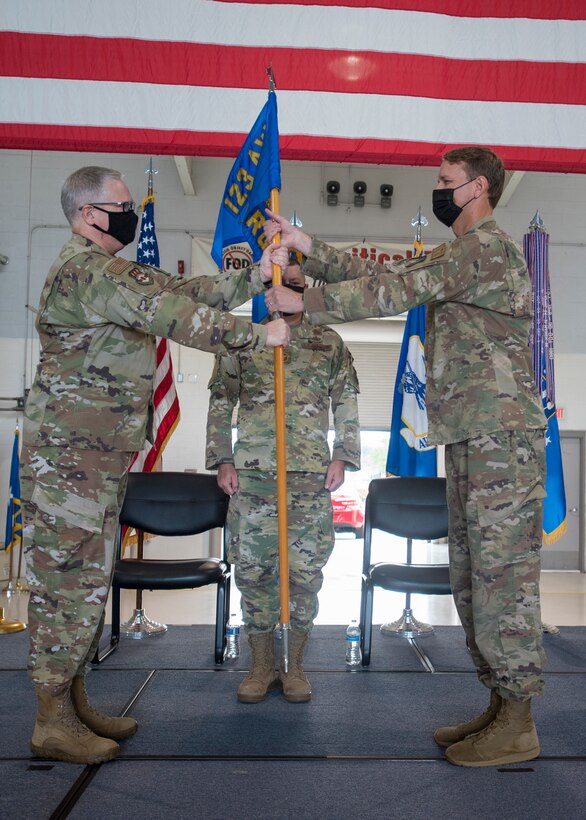 Col. Ryan Adams (right), incoming commander of the 123rd Contingency Response Group, accepts the unit’s guidon from Col. David Mounkes (left), outgoing commander of the 123rd Airlift Wing, during a change-of-command ceremony at the Kentucky Air National Guard Base in Louisville, Ky., Aug 7, 2021. Adams is replacing Col. Bruce Bancroft, who assumed command of the 123rd Airlift Wing during a ceremony later the same day. (U.S. Air National Guard photo by Phil Speck)