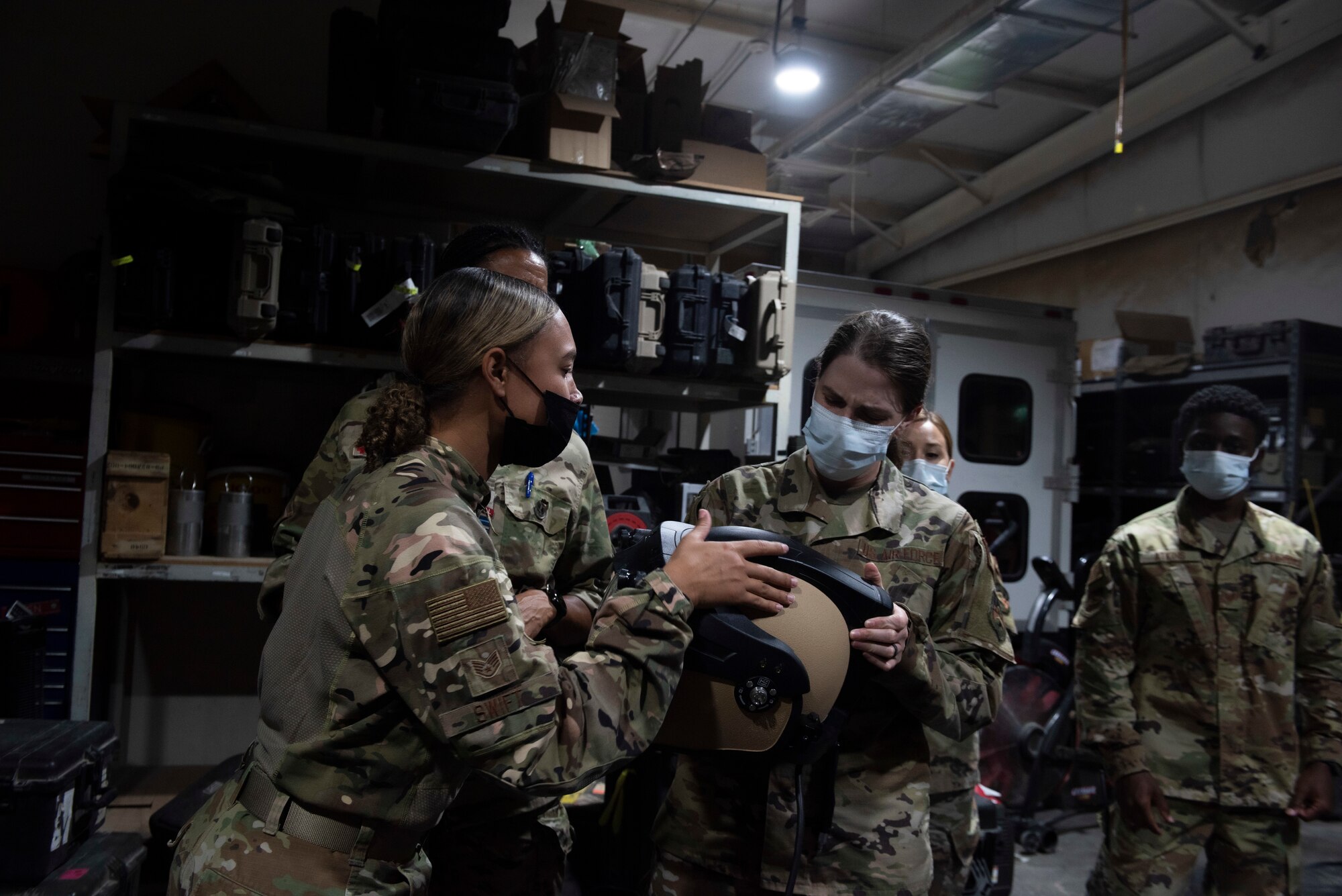 A photo of Airmen looking at a helmet