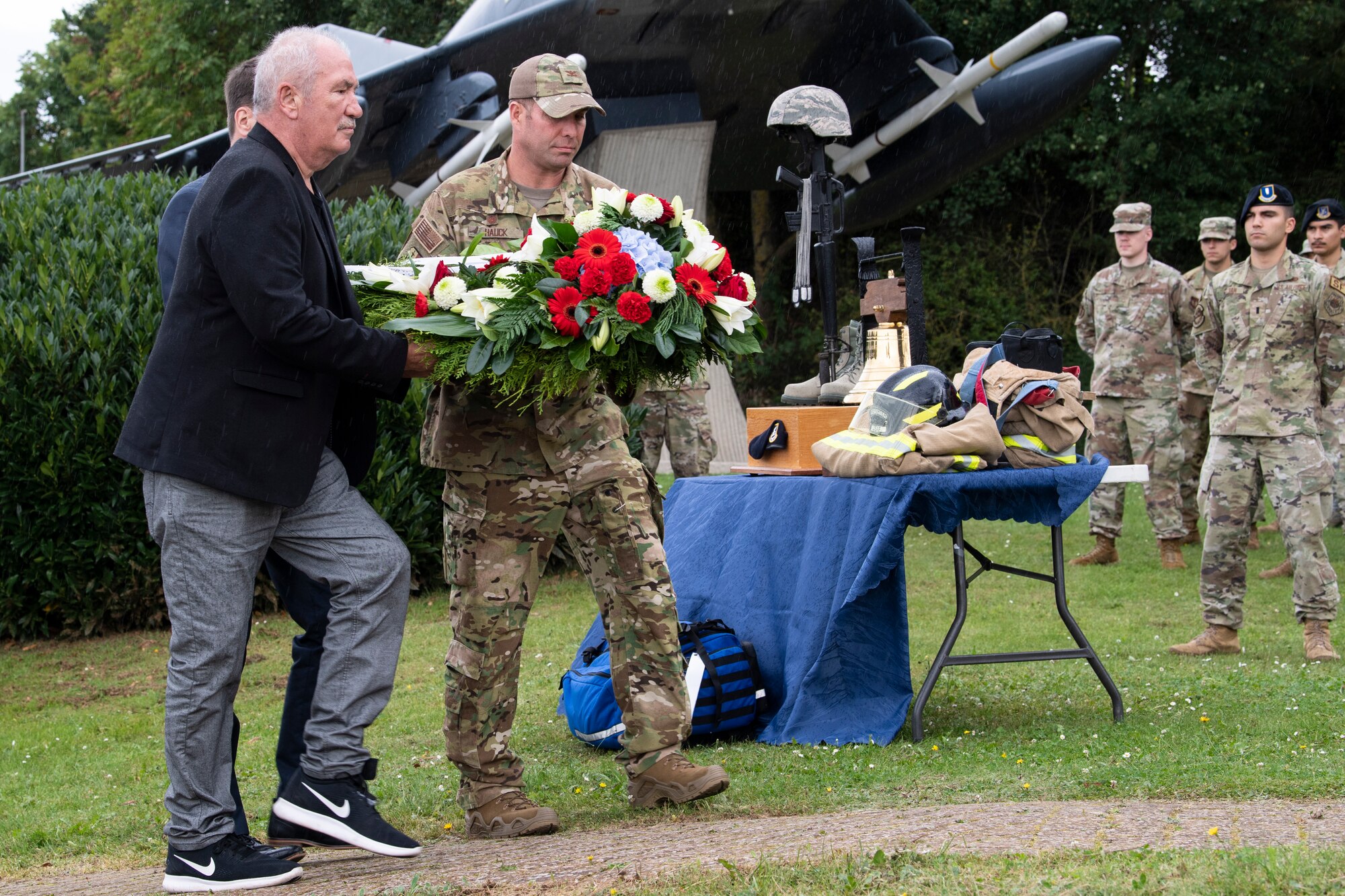 U.S. Air Force Col. Leslie Hauck, 52nd Fighter Wing commander, Herr Eric Schaefer, representative of the Ministry of the Interior/Rheinland-Pfalz, and Herr Michael Billen, Deputy County Commissioner of Bitburg, lay down a wreath in front of a 9/11 memorial during a remembrance ceremony Sept. 10, 2021, on Spangdahlem Air Base, Germany. The ceremony remembered the innocent lives that were lost during the 9/11 terrorist attack that occurred 20 years ago. (U.S. Air Force photo by Staff Sgt. Melody W. Howley)