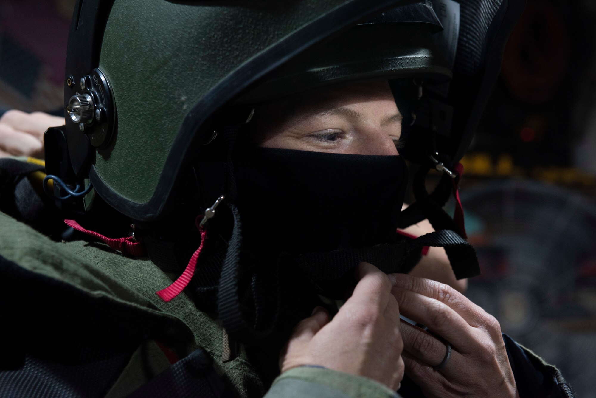 A photo of an Airman putting on a helmet