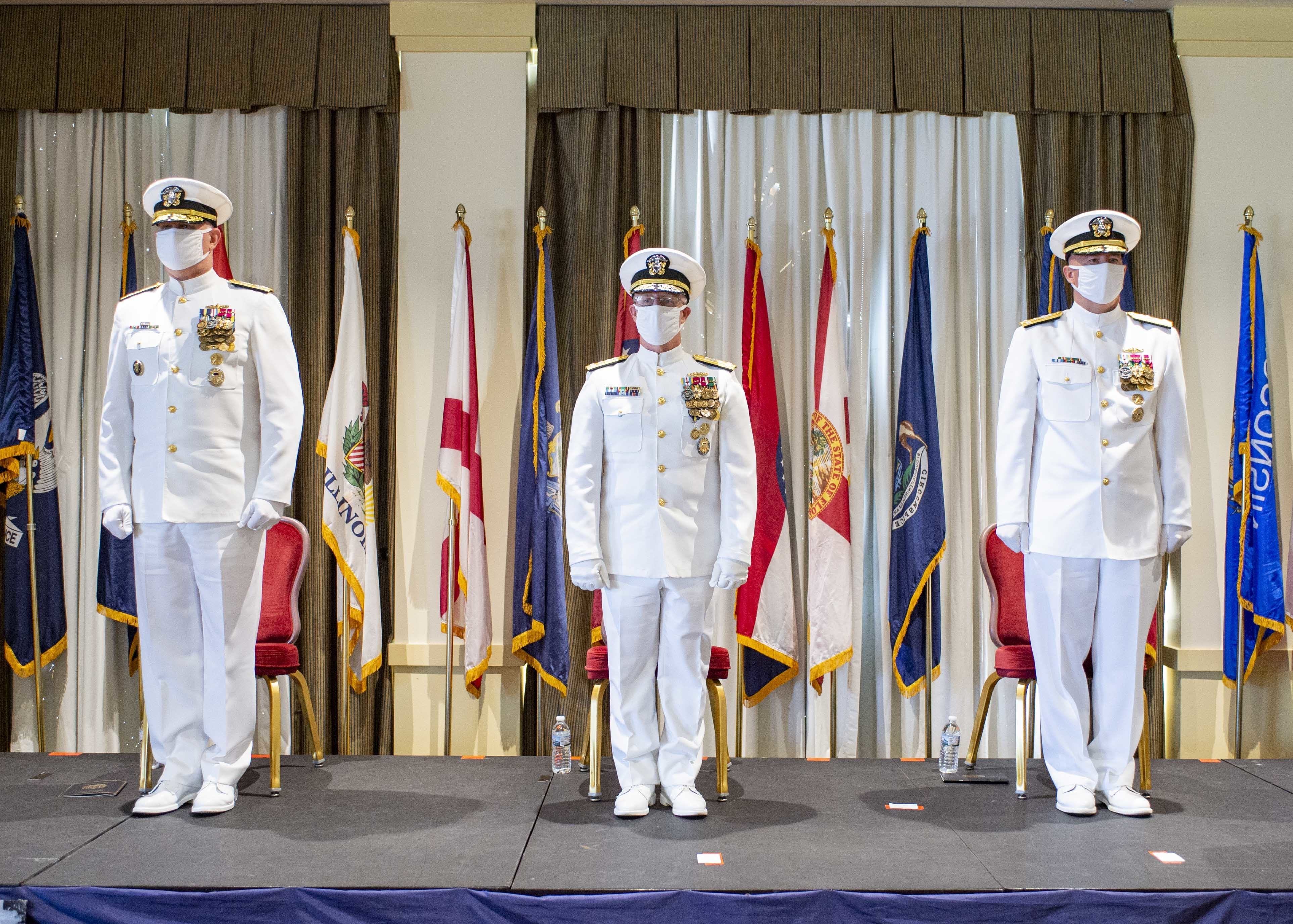 Adm. Christopher W. Grady, commander, U.S. Fleet Forces Command, left, Vice Adm. Daryl Caudle, center, and Vice Adm. William Houston, right, stand at attention during the Commander, Submarine Forces change of command ceremony in Norfolk, Va., Sept. 10, 2021.