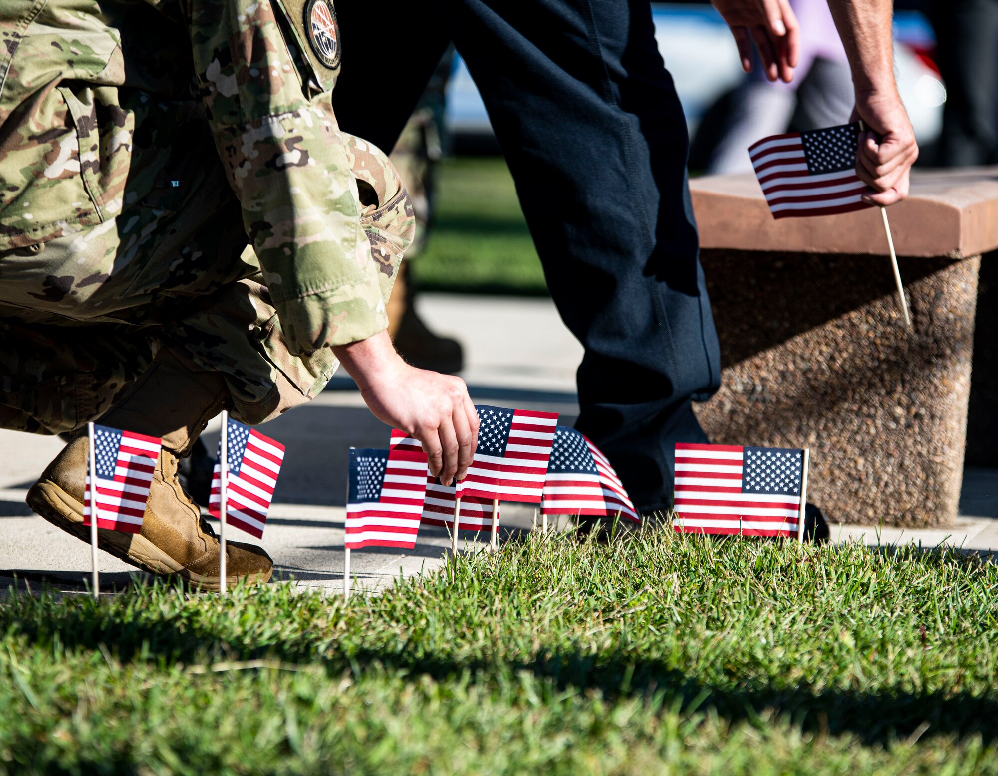 Members of the Joint Base community place flags in honor of victims of the 9/11 terrorist attacks at Joint Base McGuire-Dix-Lakehurst, N.J. Sept. 9, 2021. The event was held to honor the 20th anniversary of 9/11 where 2,977 victims lost their lives and more than 6,000 were left injured. (U.S. Air Force Photo by Airman 1st Class Matthew Porter)