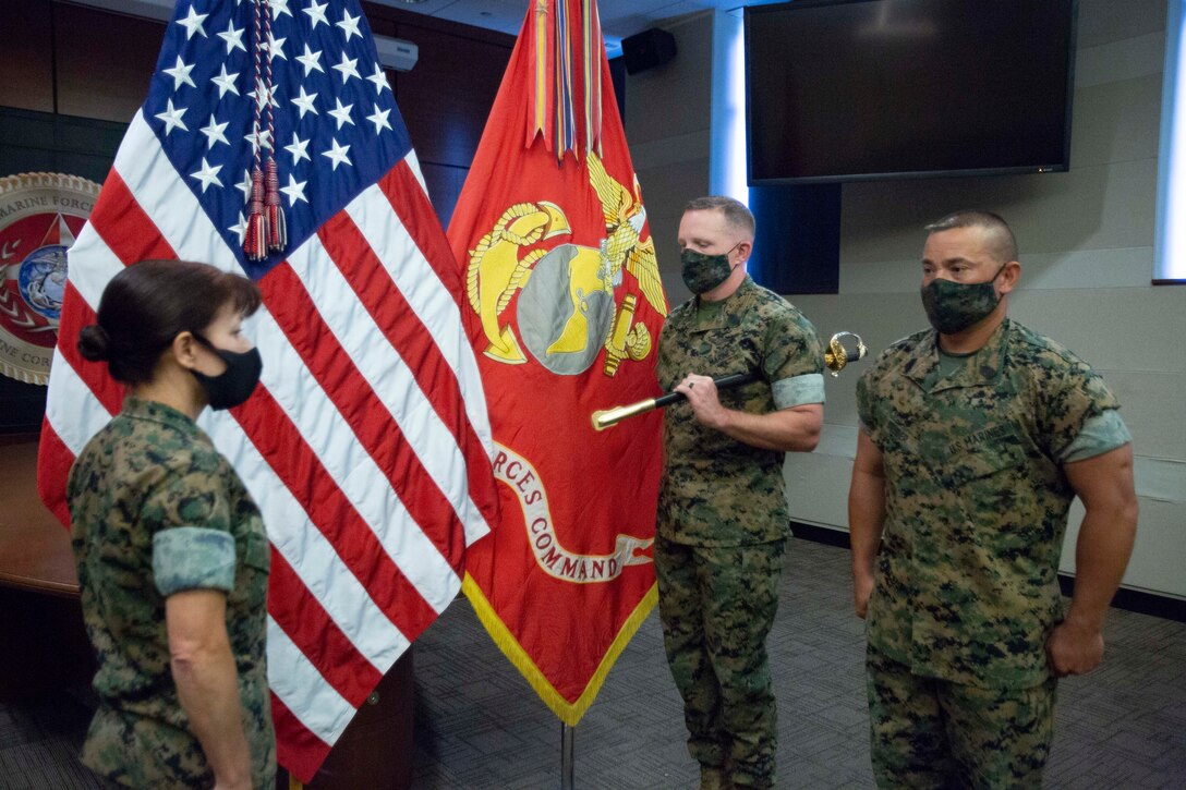 U.S. Marine Corps Sgt. Maj. Bradley S. Driver, offgoing, Marine Corps Forces Command (MARFORCOM), Marine Forces North (MARFORNORTH), Fleet Marine Forces Atlantic (FMFLANT), Headquarters and Service Battalion (HQSVCBN) Sergeant Major, relinquishes his duties to Sgt. Maj. John S. Studer, during the relief and appointment ceremony at Norfolk, Virginia, September 3, 2021. The NCO sword symbolizes the duties and responsibilities of the office of the HQSVCBN sergeant major. (U.S. Marine Corps photo by Lance Cpl. Jack Chen)