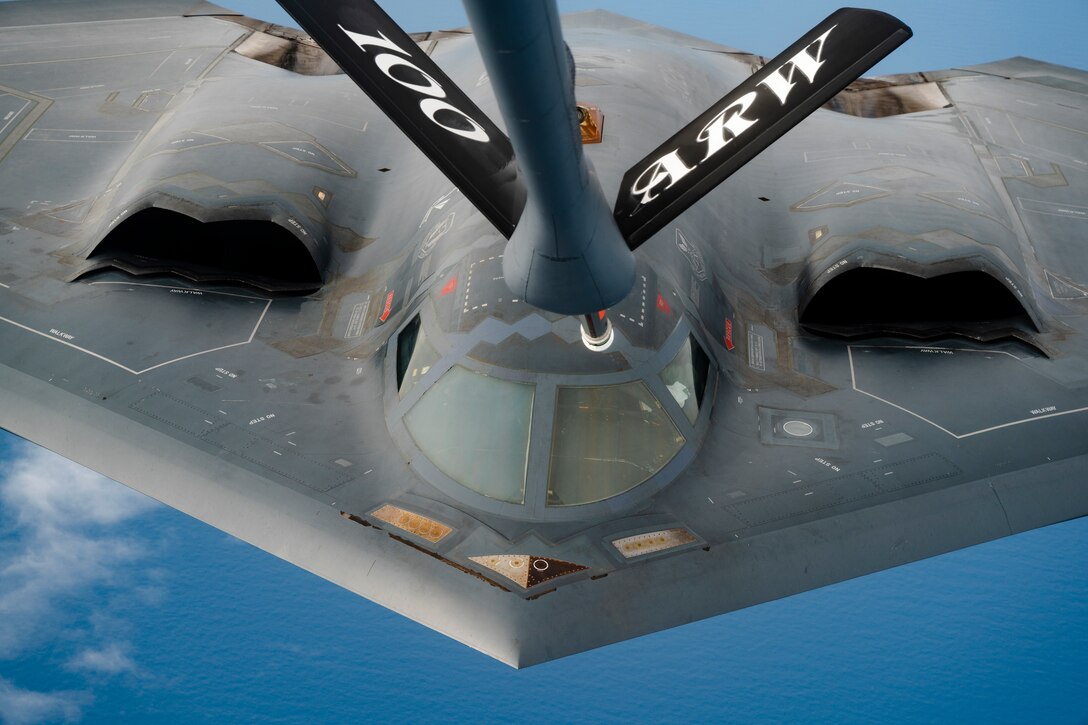 A military aircraft is refueled in flight.
