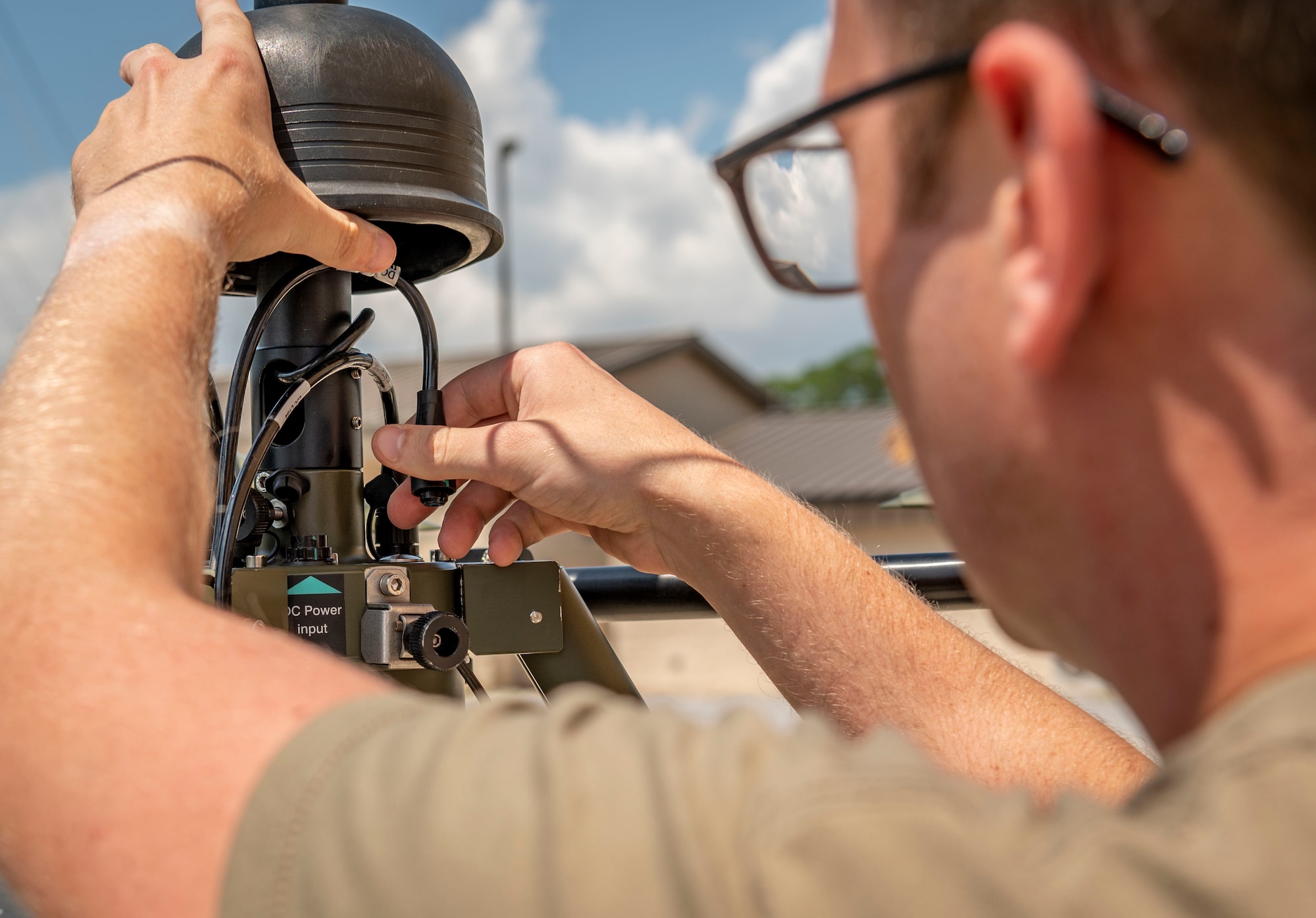 An airman disconnects a wire from a tactical meteorological observing system