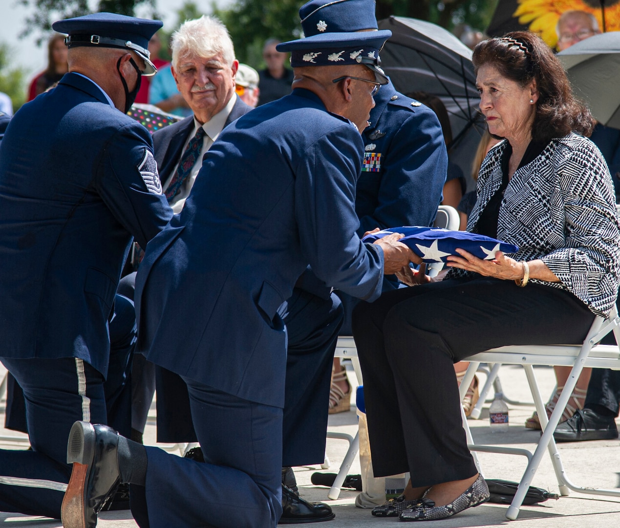 Air Force Chief of Staff Gen. CQ Brown Jr. presents the U.S. flag to retired Col. Richard E. Cole’s daughter, Cindy Chal, during his interment ceremony, Sept. 7, 2021.