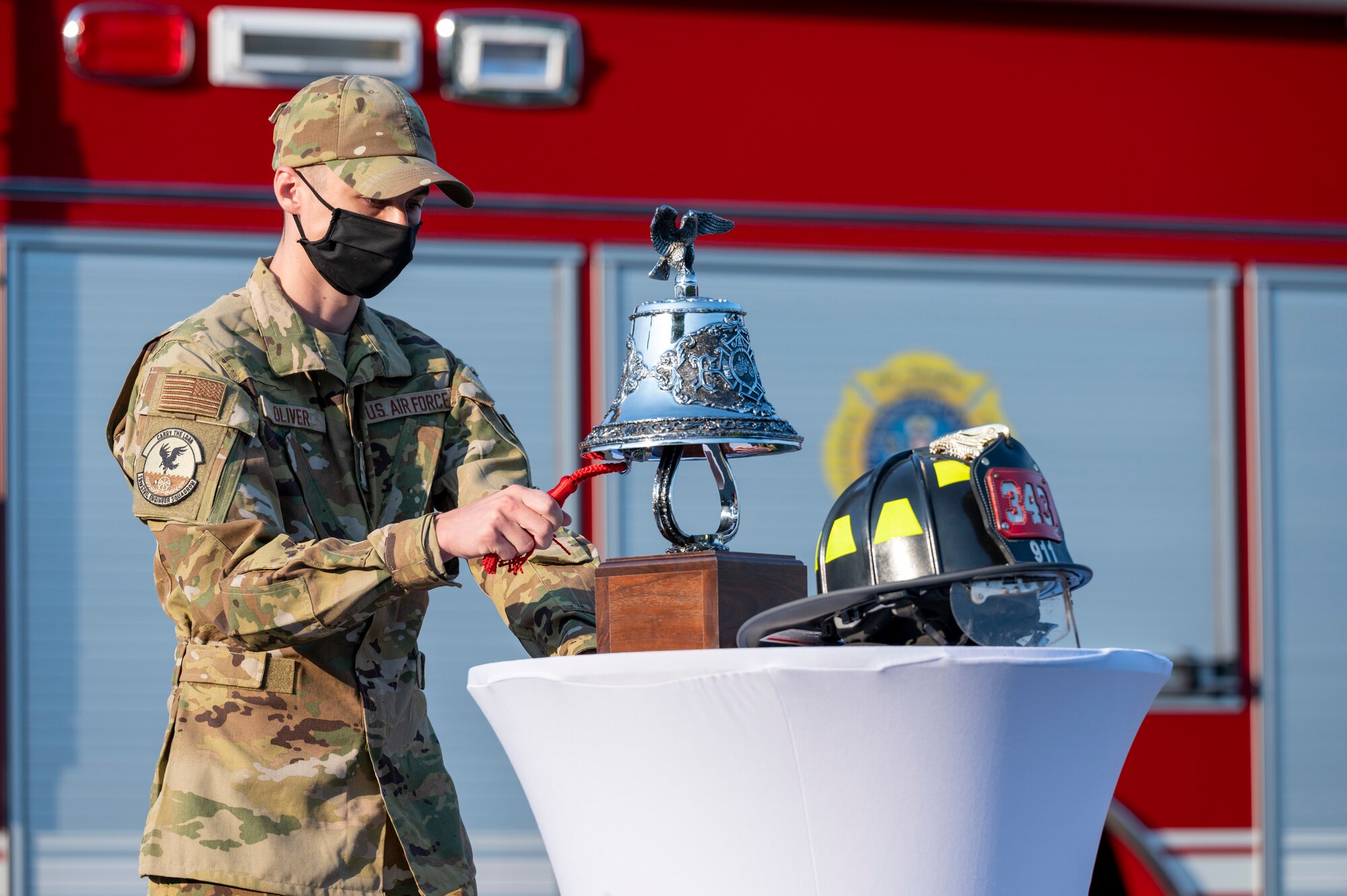 An Airman rings a ceremonial bell during a ceremony