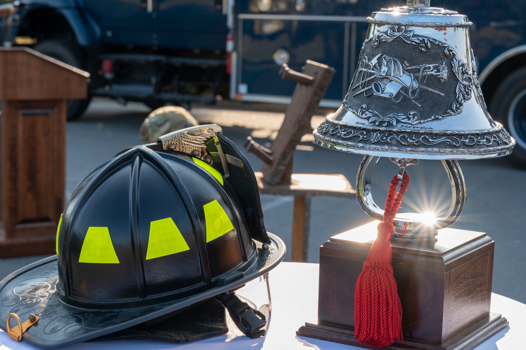 A firefighter helmet and bell are on display on a table