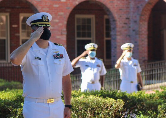 Naval Education and Training Command (NETC) staff members salute as the national anthem plays during a 9/11 memorial ceremony.