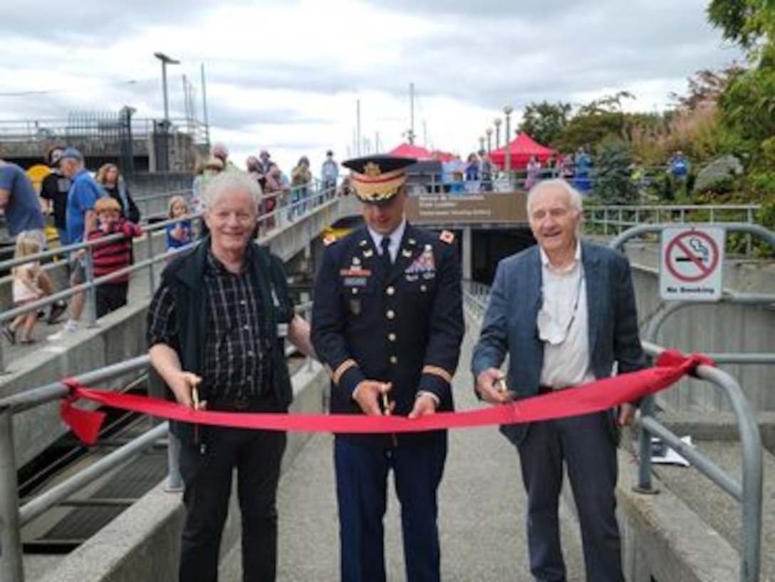 Photo of Executive Director of Discover Your Northwest, Jim Adams, Col. Alexander 'Xander' Bullock, USACE Seattle district commander, and Rich Deline, director of The Corps Foundation, cutting the red ribbon to officially open the newly renovated fish ladder viewing room to the public, at Lake Washington Ship Canal and Hiram M. Chittenden Locks, Aug. 16, 2021.