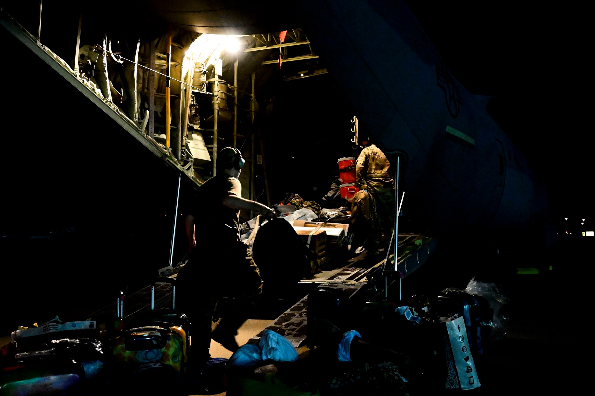 Airmen load cargo onto a C-130J