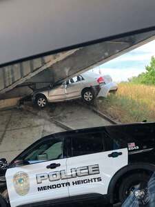 A vehicle previously occupied by two people is wedged under an overpass off I-35 after it crashed Aug. 20, 2021. Minnesota National Guard 1st Sgt. Christopher Reed, the joint operations center noncommissioned officer in charge and first sergeant of Headquarters and Headquarters Company, 1st Armored Brigade Combat Team, 34th Red Bull Infantry Division, assisted the victims.