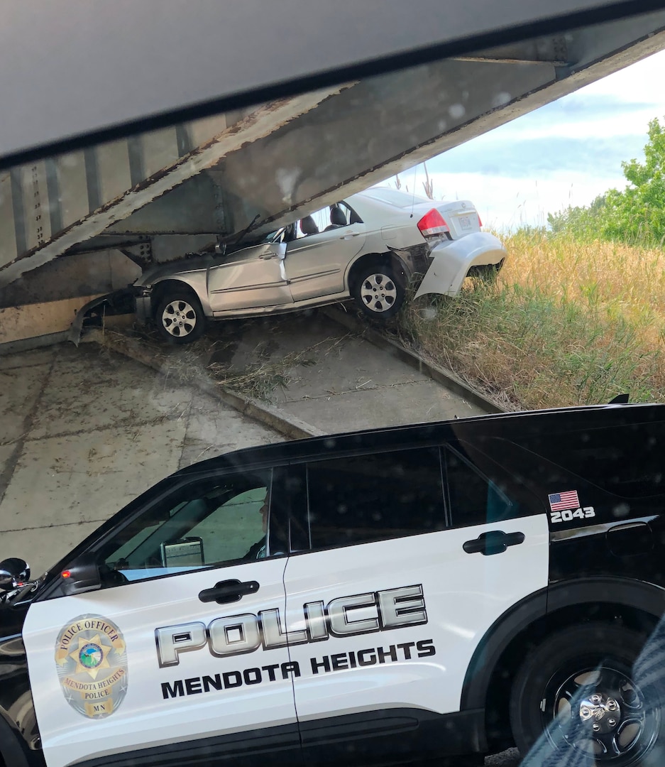 A vehicle is wedged under an overpass off of I-35 in Minnesota after it crashed Aug. 20, 2021. Minnesota National Guard 1st Sgt. Christopher Reed, the joint operations center noncommissioned officer in charge and first sergeant of Headquarters and Headquarters Company, 1st Armored Brigade Combat Team, 34th Red Bull Infantry Division, helped the two passengers, who were OK.