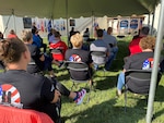 Seated individuals listen to speech during a 9/11 ceremony