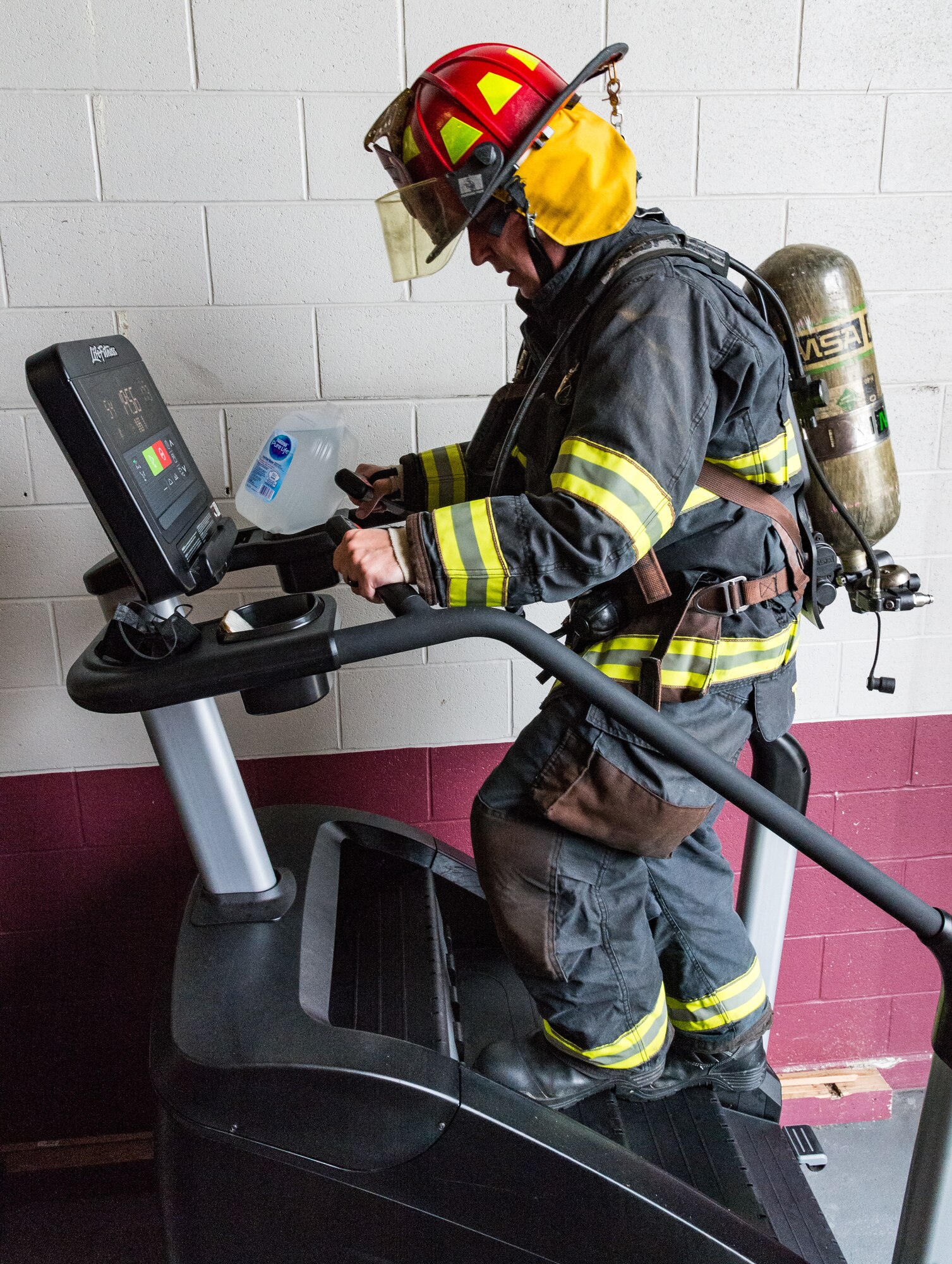 Tech. Sgt. Drew Thatcher, 436th Civil Engineer Squadron fire prevention noncommissioned officer in charge, climbs on a stair machine on Dover Air Force Base, Delaware, Sept. 9, 2021. Wearing fire protection gear, Thatcher climbed 110 stories, the same amount as the World Trade Center towers. (U.S. Air Force photo by Roland Balik)