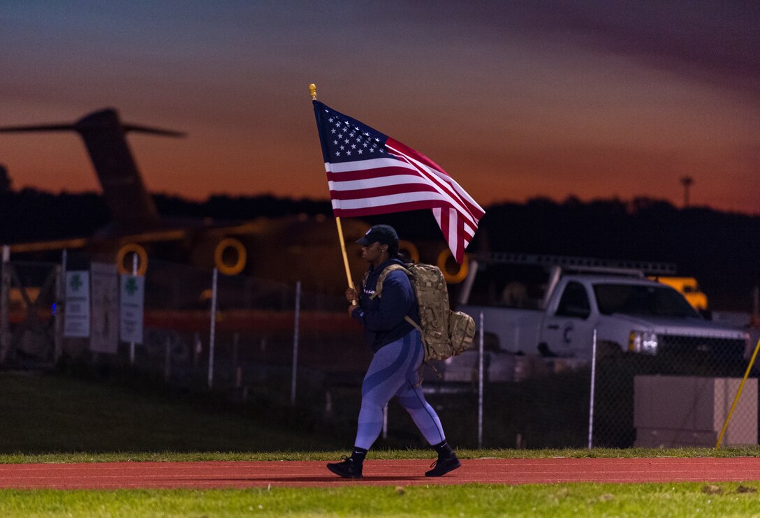 Master Sgt. Ashley Daniel, 436th Security Forces Squadron installation security manager, holds the U.S. flag during the 9/11 Remembrance Ruck March on Dover Air Force Base, Delaware, Sept. 10, 2021. Daniel, as well as other Team Dover members, rucked in 30-minute increments for more than 25 hours, remembering and honoring those who perished in the attacks on Sept. 11, 2001. (U.S. Air Force photo by Roland Balik)