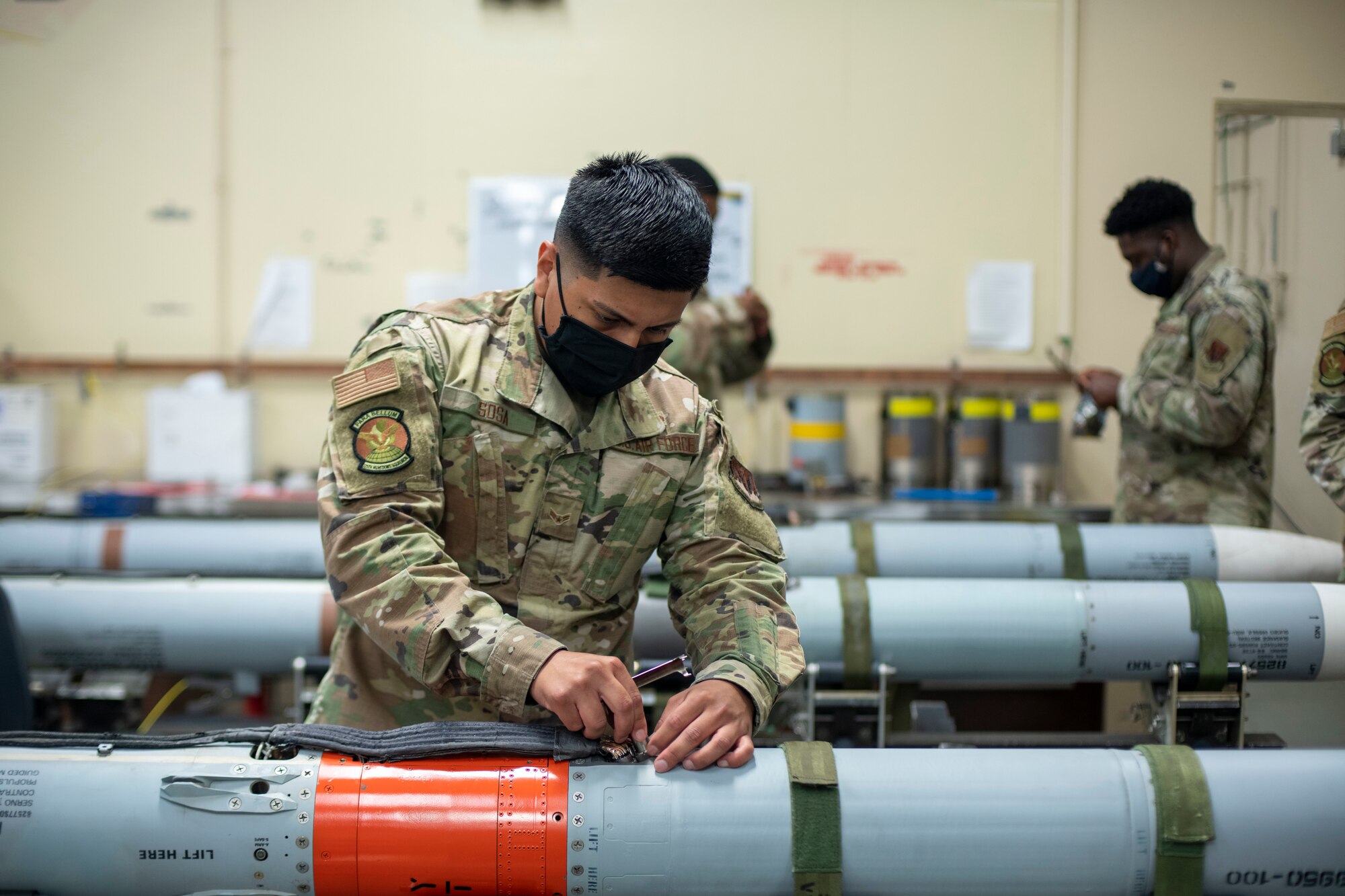 Man uses a tool to secure a spacer on a missile
