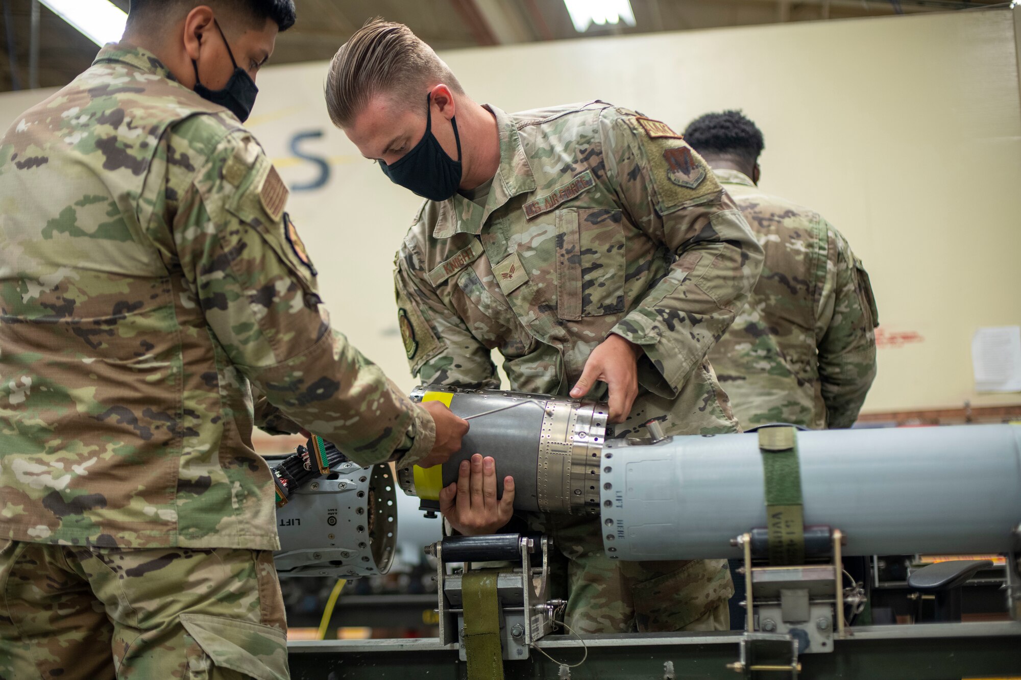Two men place a spacer on a missile
