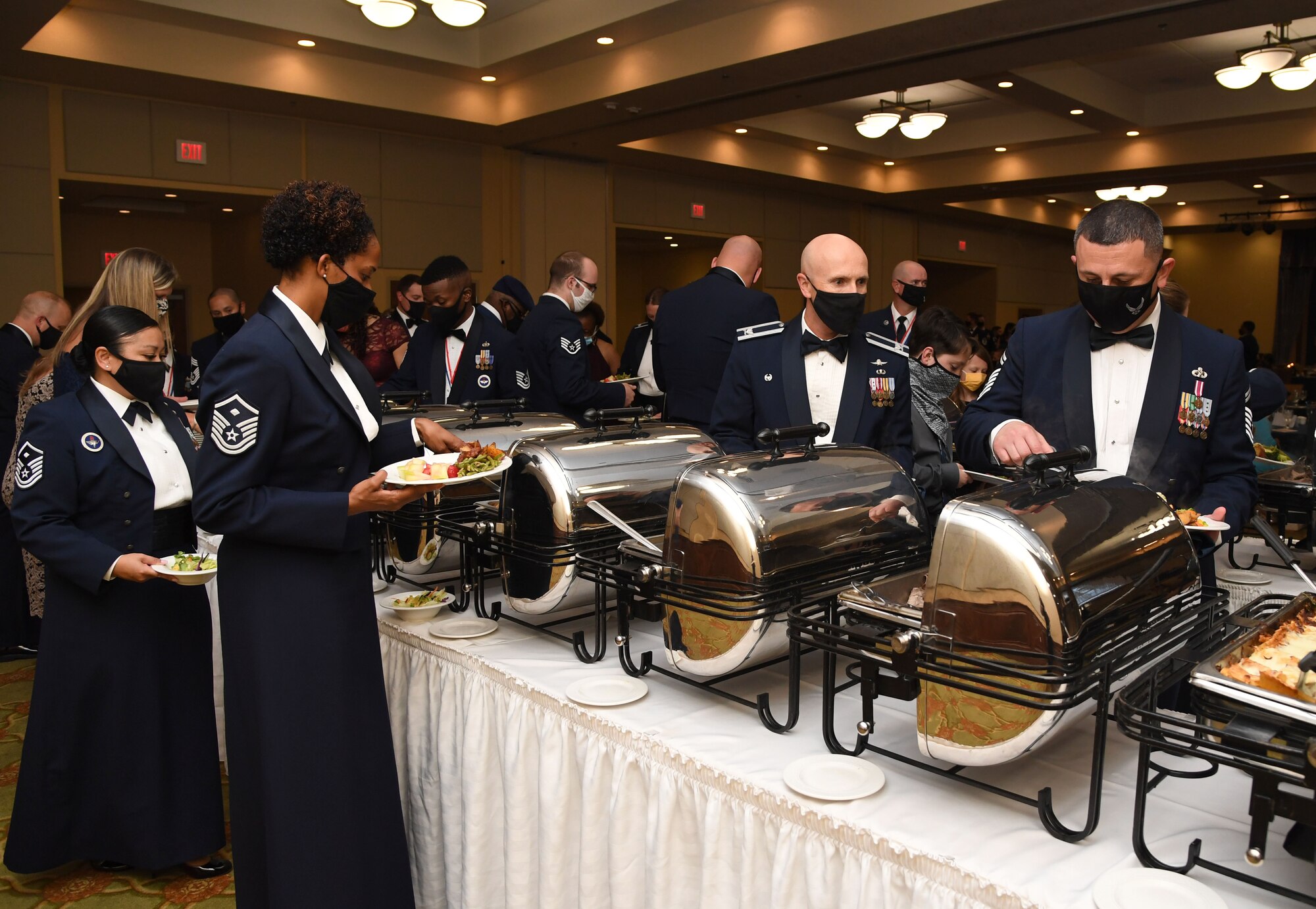 Keesler personnel make their way through the buffet line during the Senior NCO Induction Ceremony inside the Bay Breeze Event Center at Keesler Air Force Base, Mississippi, Sept. 10, 2021. More than thirty enlisted members were recognized during the event. (U.S. Air Force photo by Kemberly Groue)