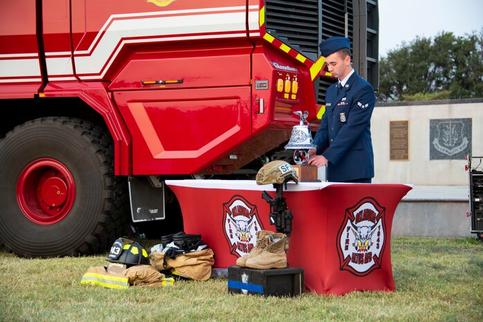 U.S. Air Force Airman 1st Class Joseph McGee Coveney, 97th Civil Engineer Squadron firefighter, performs the Last Alarm during the 97th Air Mobility Wing Remembrance Ceremony at Altus Air Force Base, Oklahoma, Sept. 11, 2021. The Last Alarm Ceremony is a fire service tradition dating back to the 1800’s, and is used today as a form of rendering final honors to departed comrades. (U.S. Air Force photo by Senior Airman Amanda Lovelace)