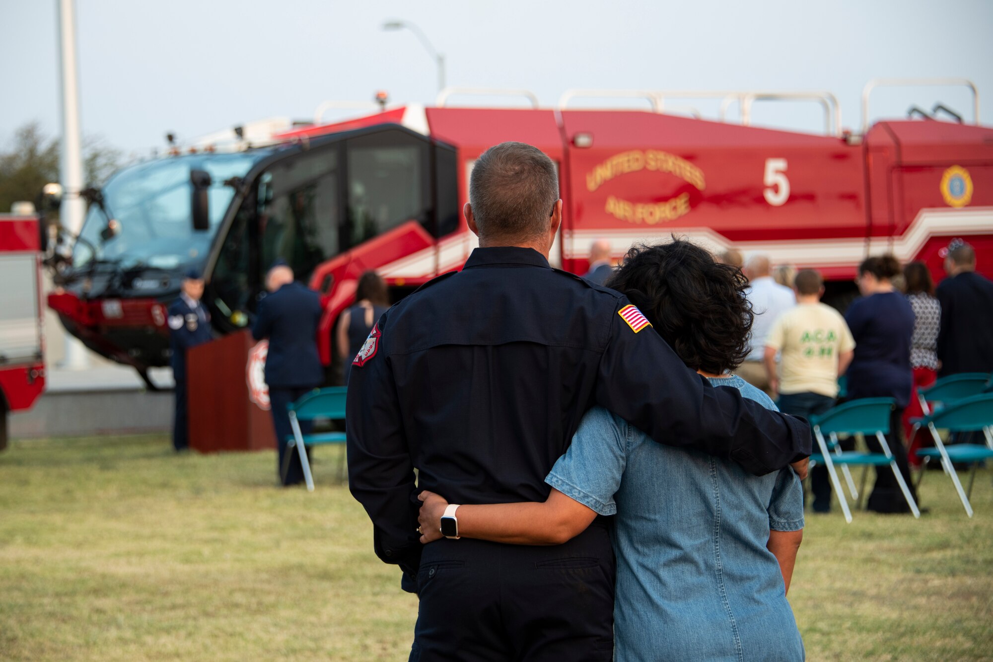 Philip Fourroux, 97th Civil Engineer Squadron installation fire chief, left, and his wife comfort each other during the 97th Air Mobility Wing Remembrance Ceremony at Altus Air Force Base, Oklahoma, Sept. 11, 2021. This is the tenth year the base has held a 9/11 memorial ceremony as a wing-level event for all Airmen. (U.S. Air Force photo by Senior Airman Amanda Lovelace)