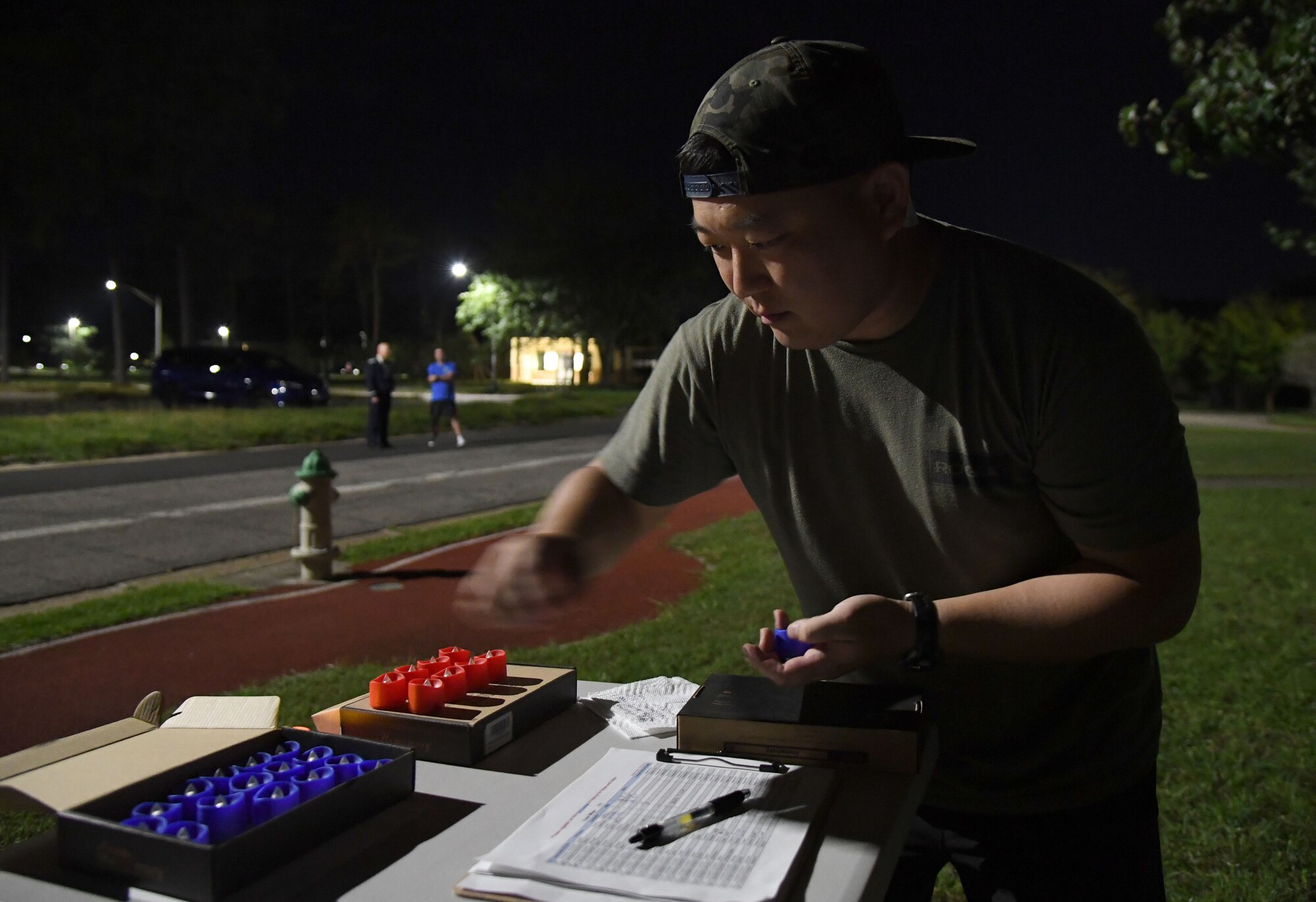 U.S. Air Force 2nd Lt. James Ro, 333rd Training Squadron student, prepares flameless candles for runners outside of Stennis Hall during the 2nd Annual 9/11 Memorial Run at Keesler Air Force Base, Mississippi, Sept. 10, 2021. The 24-hour run honored those who lost their lives during the 9/11 attacks. (U.S. Air Force photo by Kemberly Groue)