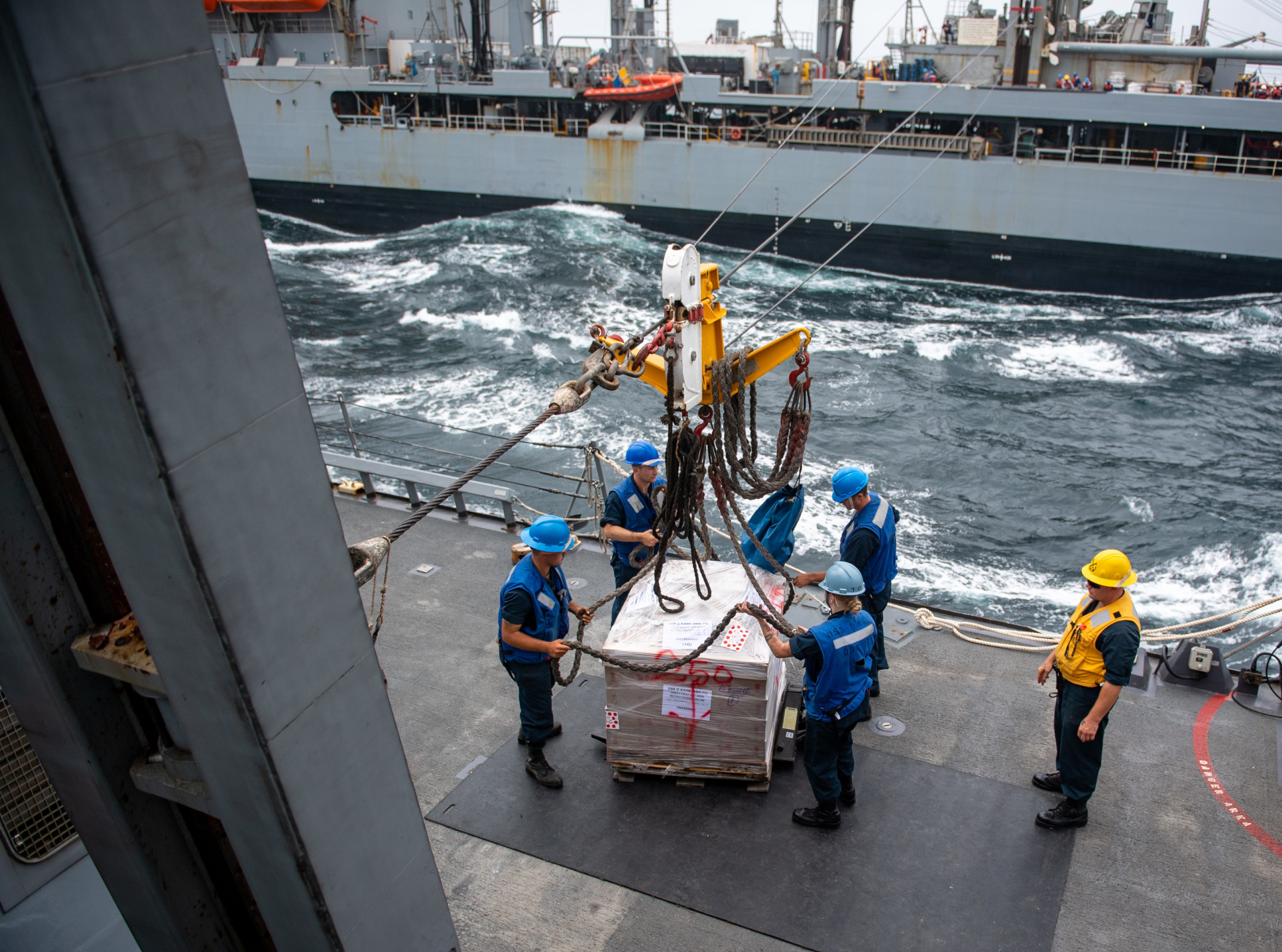 Sailors aboard the guided-missile destroyer USS O'Kane (DDG 77) receive cargo during a replenishment-at-sea with underway replenishment oiler USNS Pecos (T-AO 197) in the Arabian Sea.