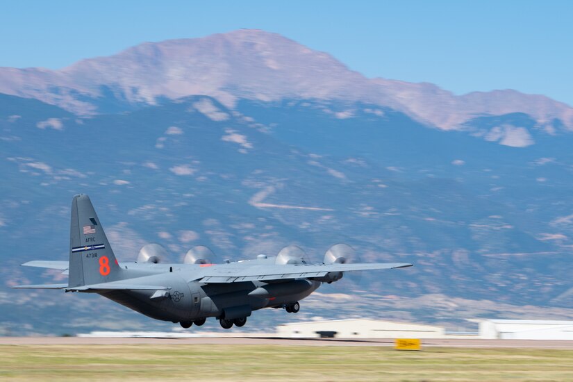 An aircraft takes off near mountains.