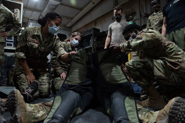 A photo of medics taking off a bomb suit