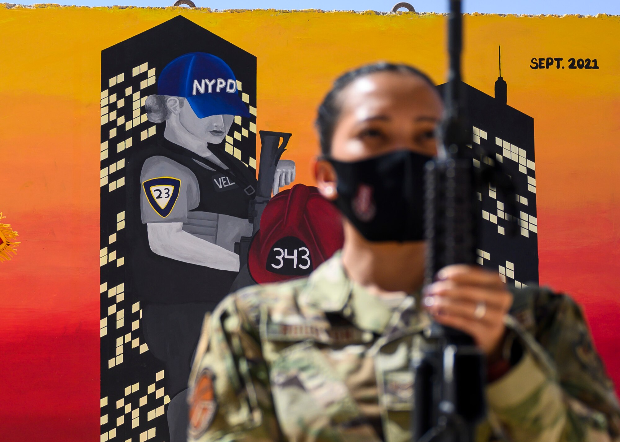 U.S. Air Force Staff Sgt. Aubrey Houston, 378th Expeditionary Security Forces Squadron defender, posts with her weapon in front of a memorial mural during the playing of the national anthem in a Remembrance Ceremony Sept. 11, 2021, at Prince Sultan Air Base, Kingdom of Saudi Arabia.