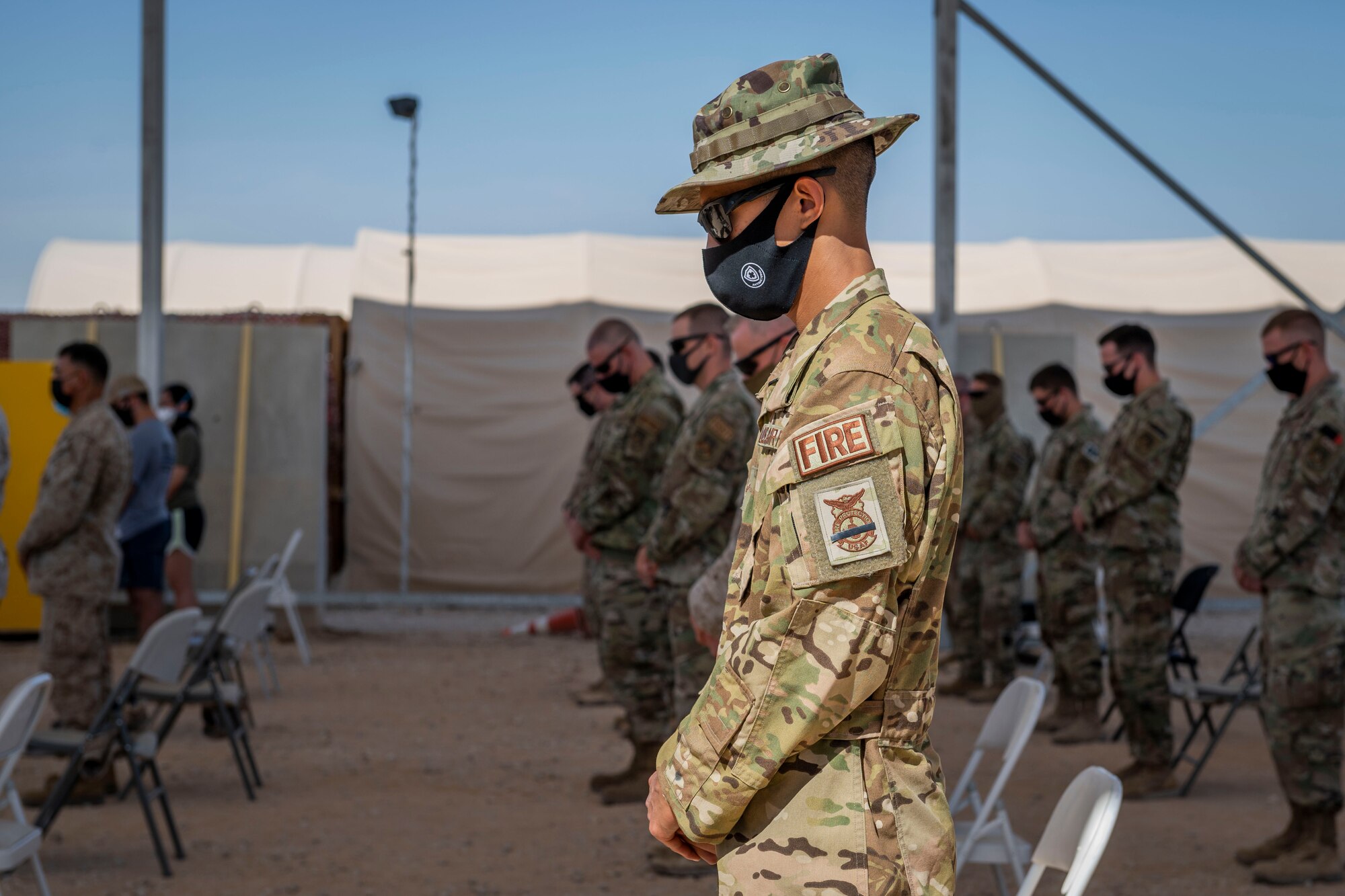 Members of the 378th Air Expeditionary Wing stand for prayer during a Remembrance Ceremony Sept. 11, 2021, at Prince Sultan Air Base, Kingdom of Saudi Arabia.