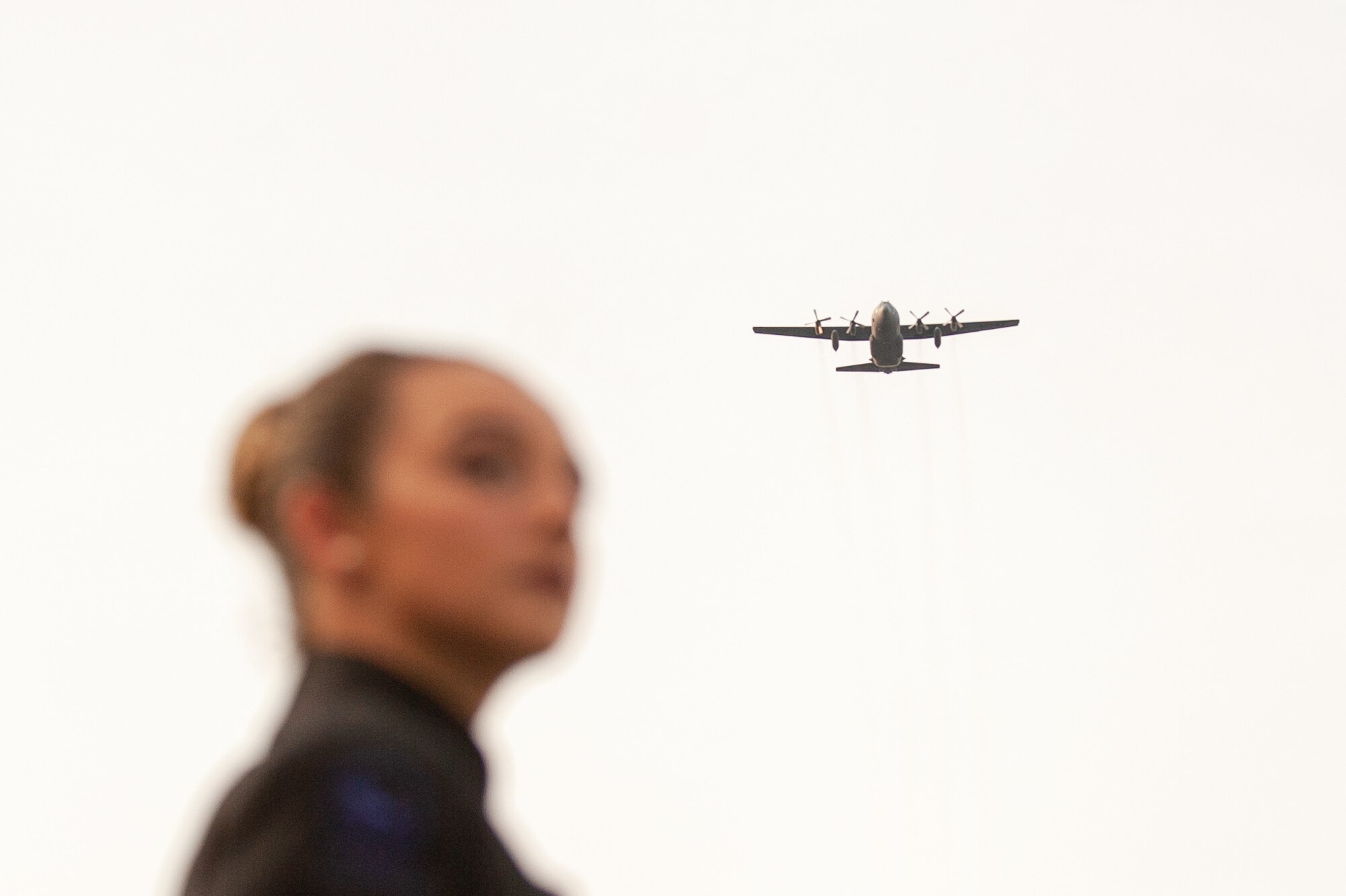 woman looks on as a c-130 approaches