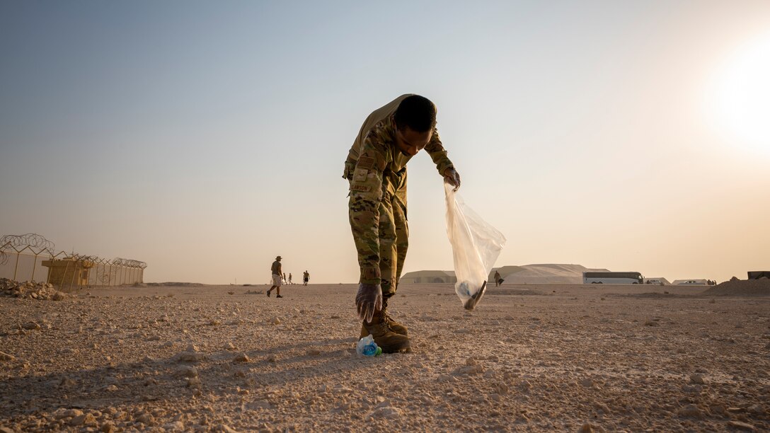 Airman 1st Class Marquis Clawson, 379th Expeditionary Logistics Readiness Squadron ground transportation support operator, picks up an empty water bottle on the flightline Sept. 8, 2021, at Al Udeid Air Base, Qatar.