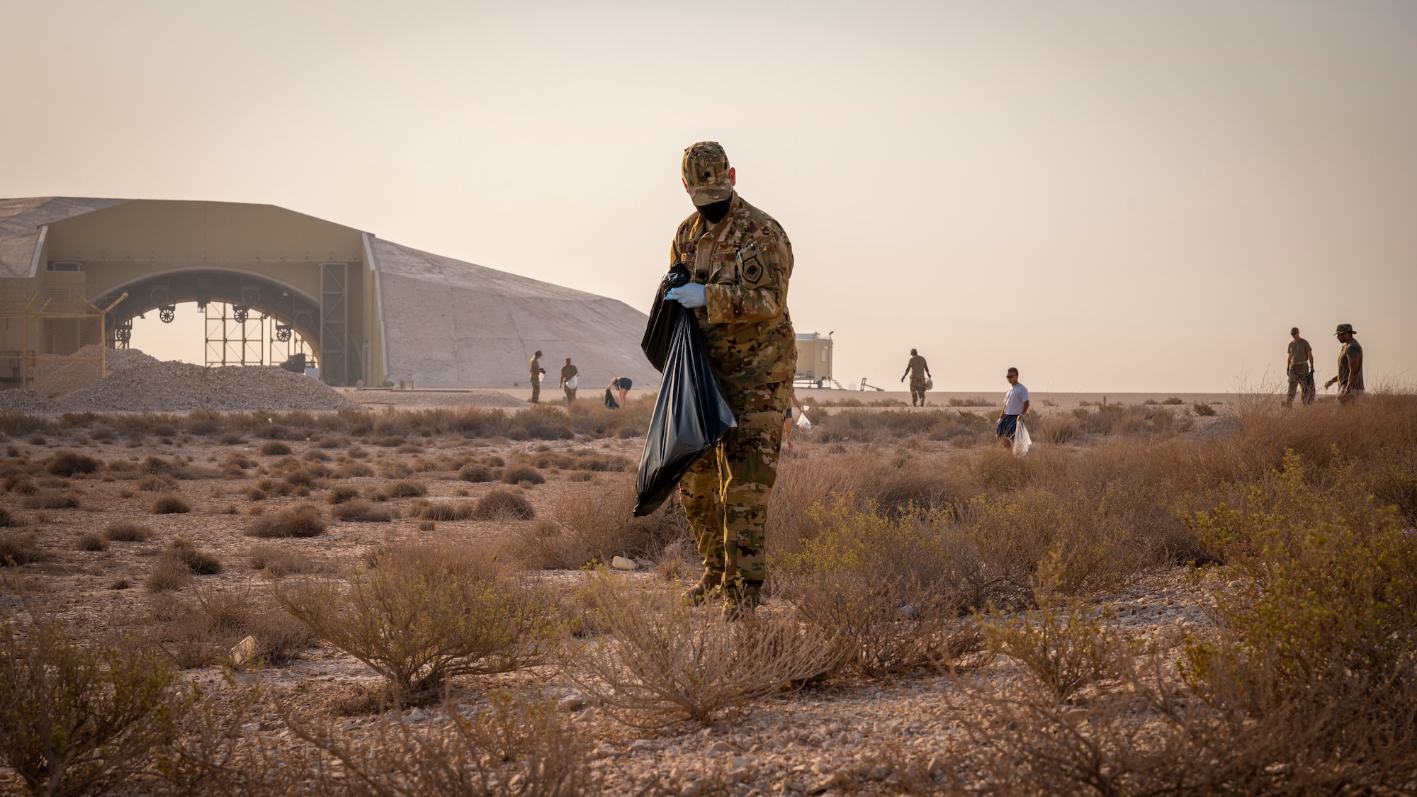 An Airman picks up foreign object debris on the flightline Sept. 8, 2021, at Al Udeid Air Base, Qatar.