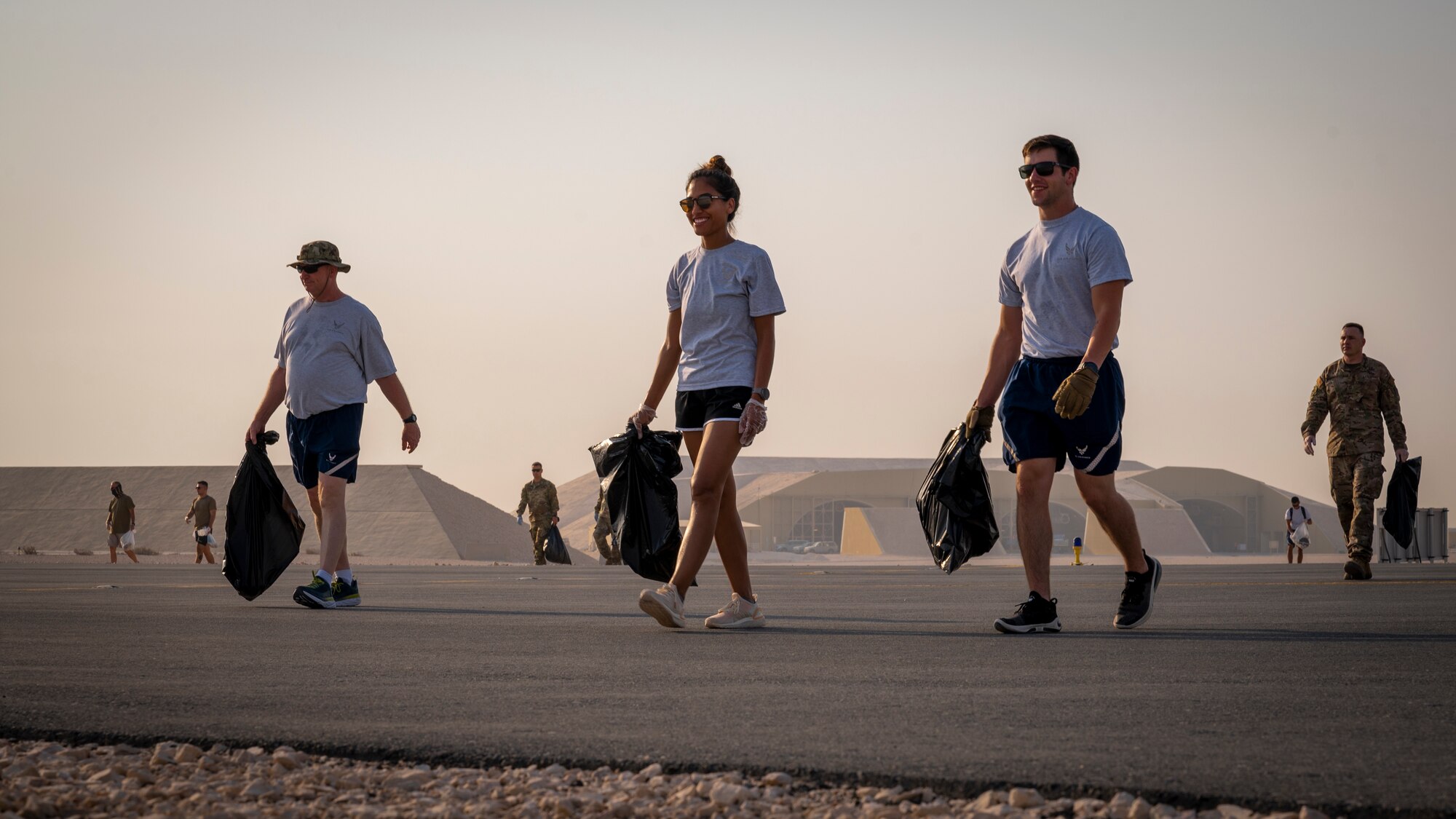 Service members walk across a taxiway on the flightline Sept. 8, 2021, at Al Udeid Air Base, Qatar.