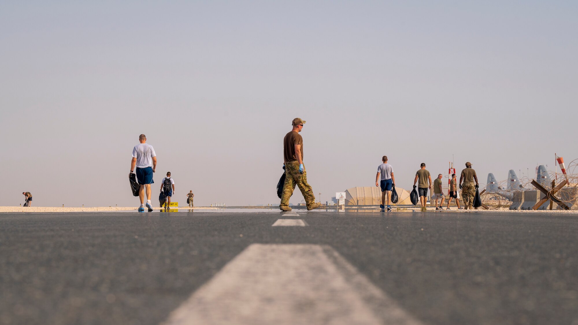 Service members walk down the flightline Sept. 8, 2021, at Al Udeid Air Base, Qatar.